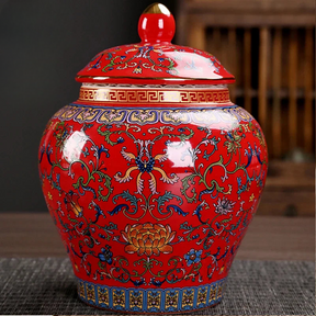 a red vase with a lid sitting on a table