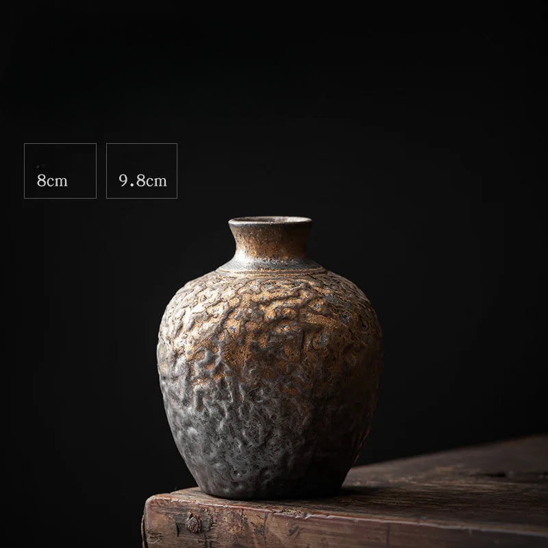 a brown vase sitting on top of a wooden table