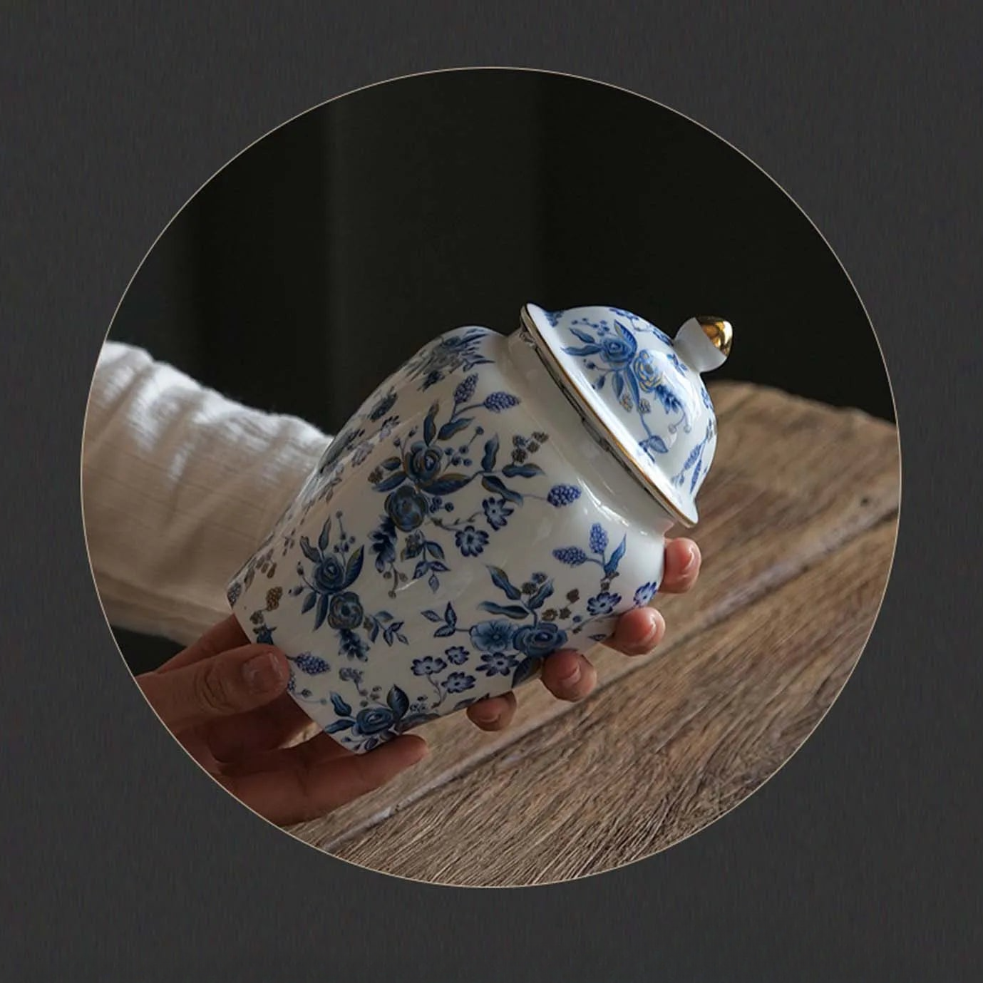 a person holding a blue and white tea pot