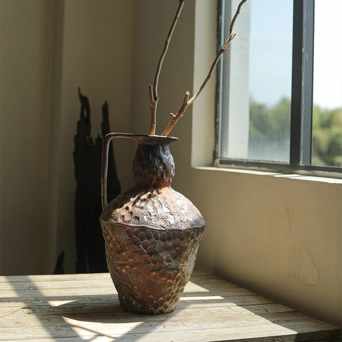 a vase with a branch in it sitting on a table