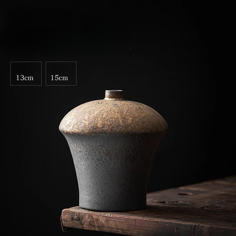 a black vase sitting on top of a wooden table