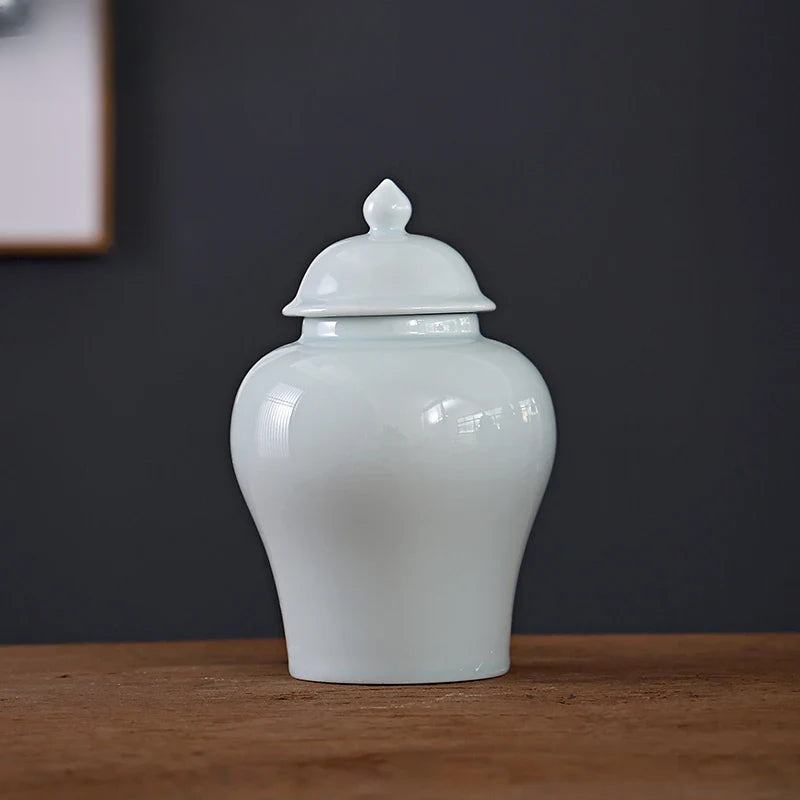 a white vase sitting on top of a wooden table