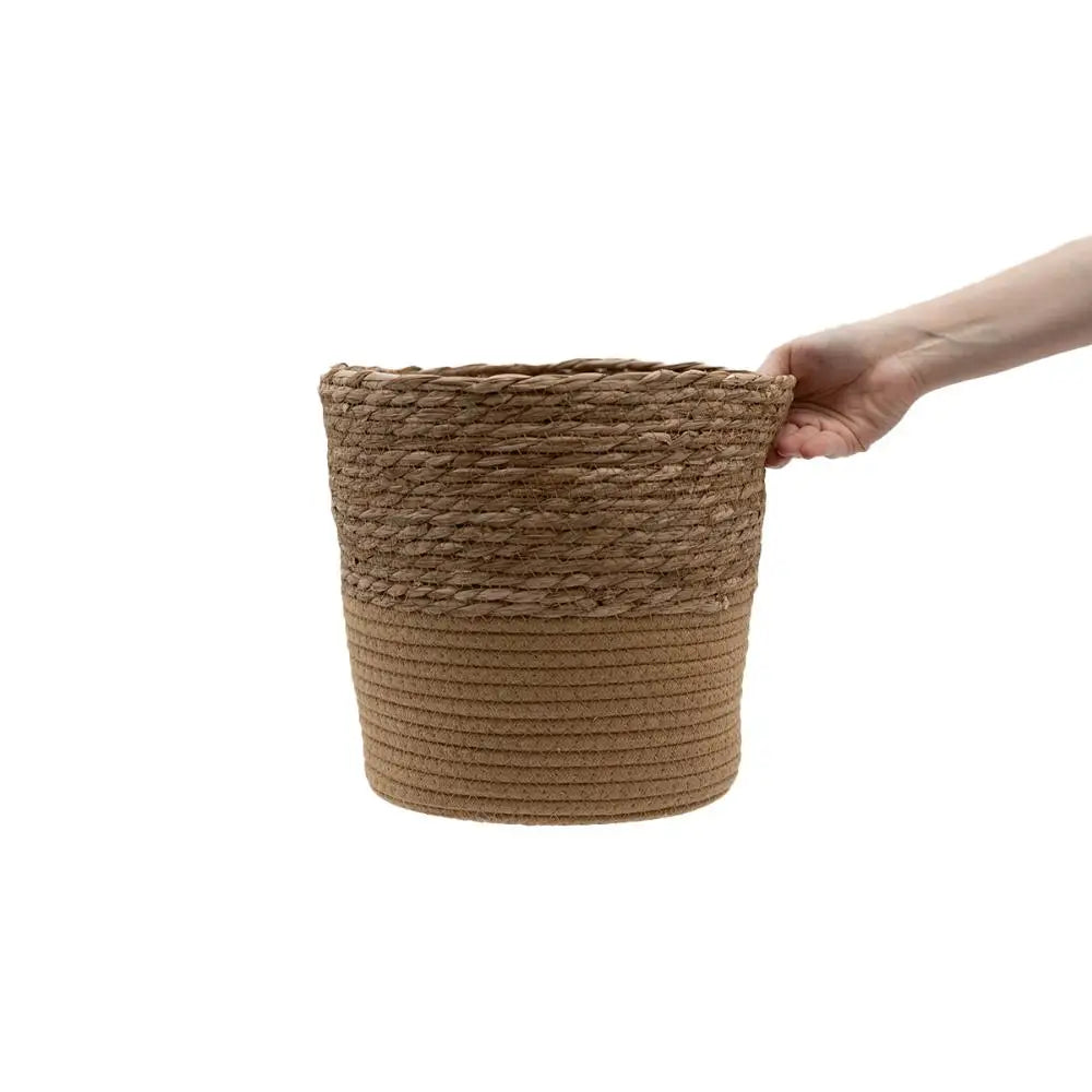 a hand holding a rope wrapped basket on a white background