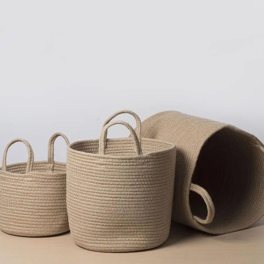 three woven baskets sitting on top of a wooden table