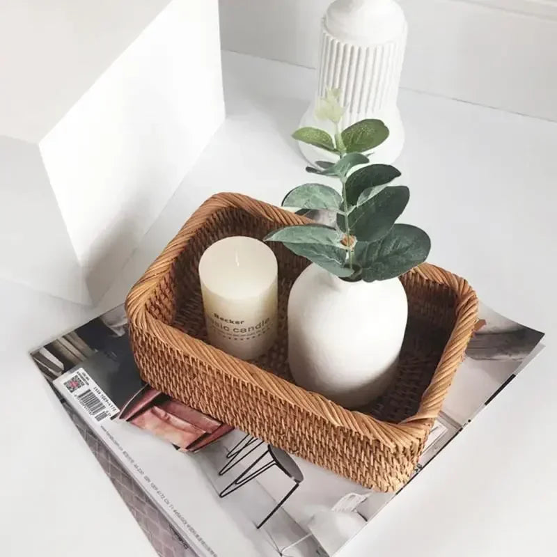 a basket with two candles and a potted plant