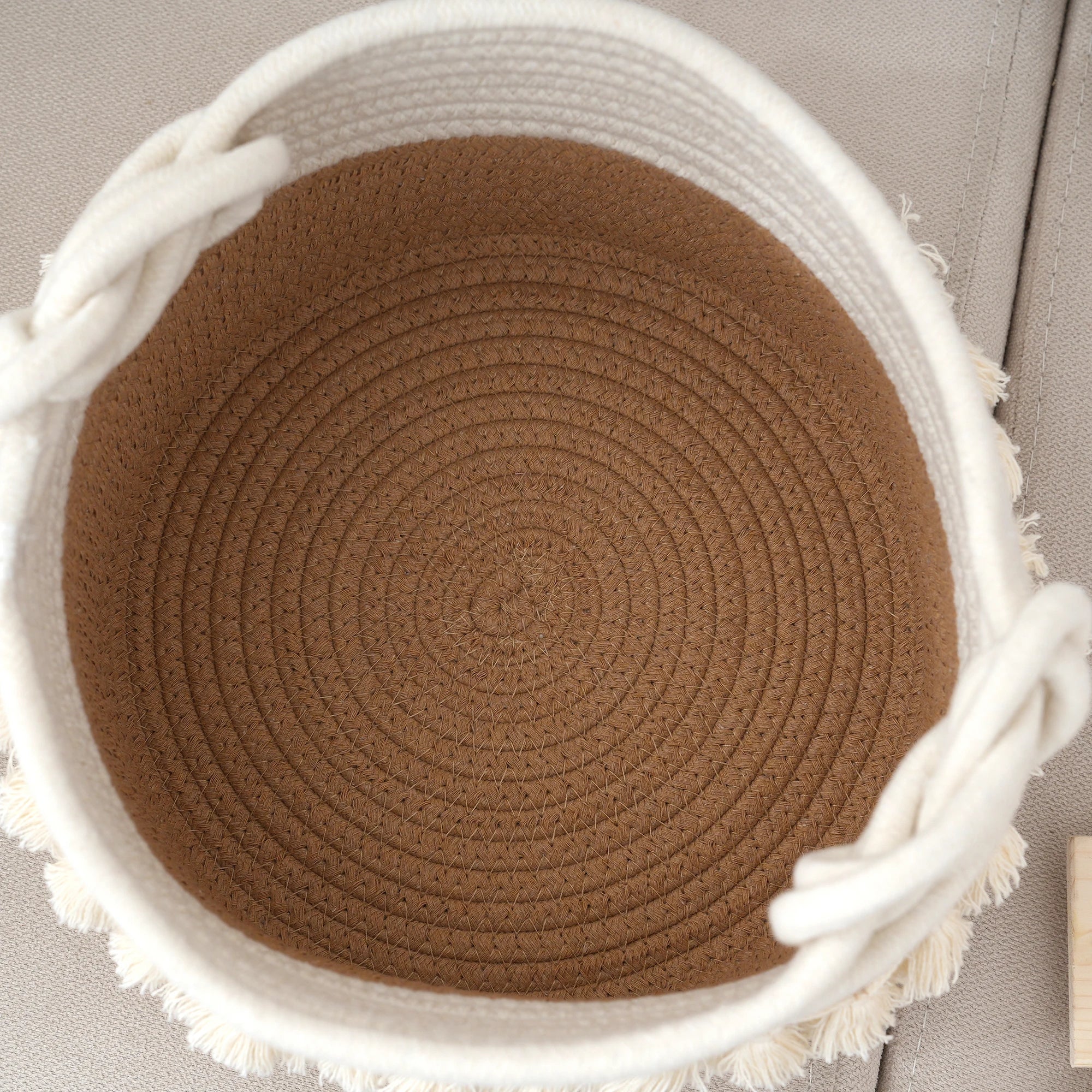 a brown and white basket sitting on top of a couch