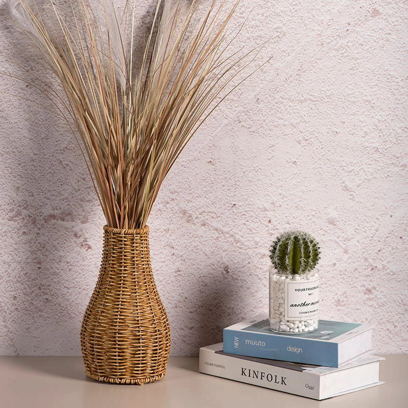 a plant in a vase next to a stack of books