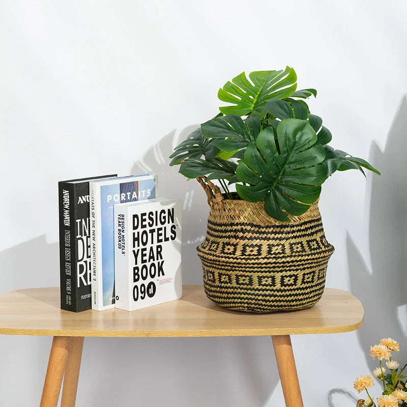 a wooden table topped with a plant and two books