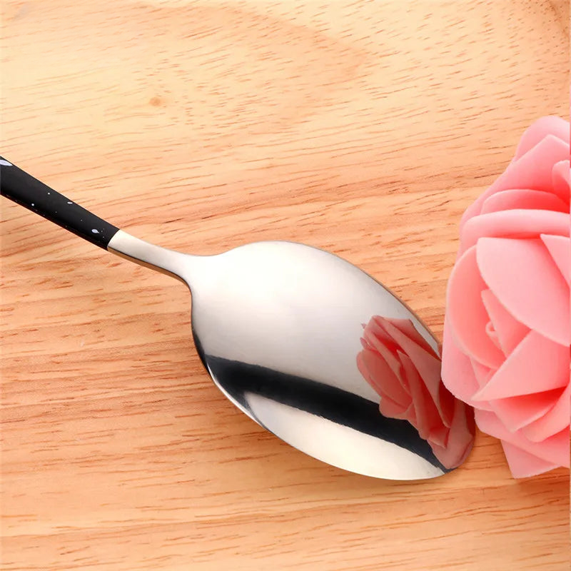 a spoon with a flower on it sitting on a table