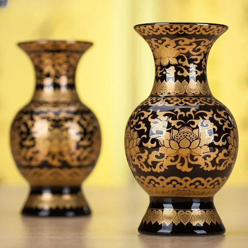 two black and gold vases sitting on a table