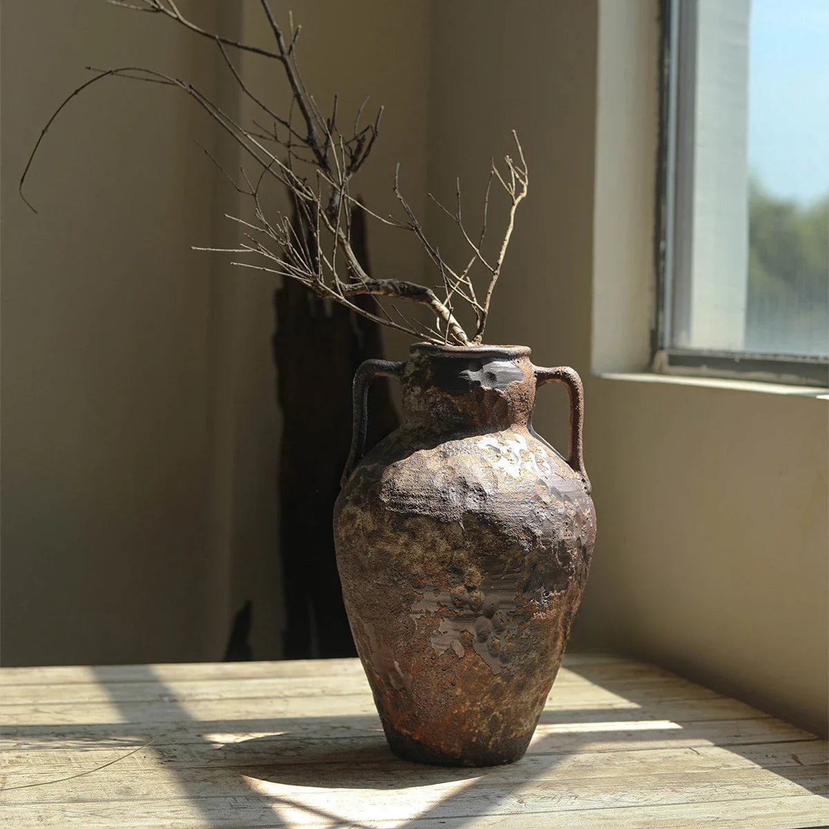 a brown vase sitting on top of a wooden table